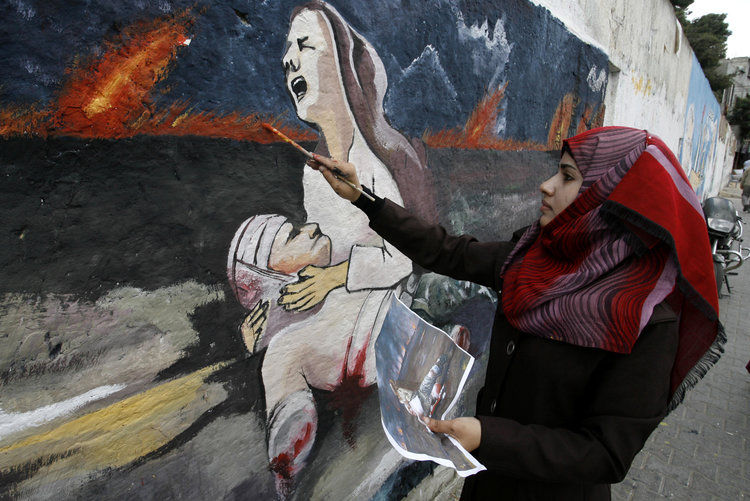 E8WRB6 Rafah, Gaza Strip, Palestinian Territory. 15th Oct, 2014. A Palestinian girl paints a mural on a wall depicts a woman crying as she holds her killed husband referring to the Israeli offensive seven weeks, in Rafah in the southern Gaza Strip, October 5, 2014. Israel opened the border to the first truckloads of building materials for post-war reconstruction in Gaza on Tuesday and U.N. Secretary General Ban Ki-moon called the destruction in the Palestinian enclave ''beyond description © Abed Rahim Khatib/APA Images/ZUMA Wire/Alamy Live News